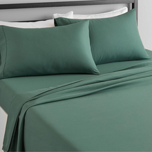 Load image into Gallery viewer, Emerald green deep pocket fitted sheet and pillowcases styled on a bed

